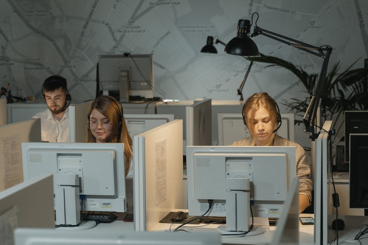 services-03 Call center agents working diligently with computers and headphones, providing customer support.